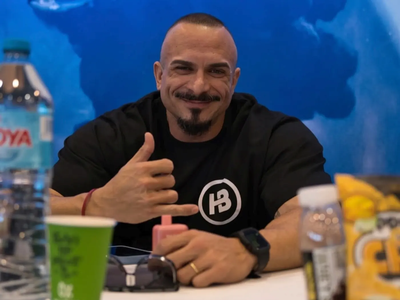Atleta con la camiseta de Healthy Body Nutrition en el stand de la marca