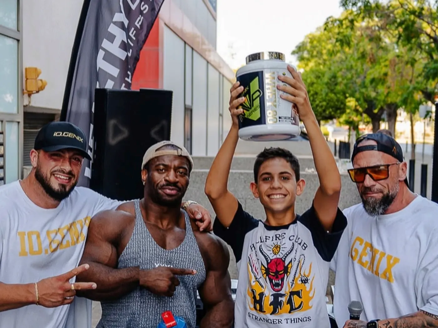 Atletas de iO.GENIX con un cliente joven en un evento de Healthy Body Nutrition